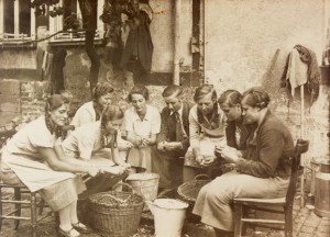 Sechs Kirmesmädchen, unterstütz von einem Kirmesburschen, beim Kartoffelschälen für den "3. Kirmestag" (Dienstag) 1935.